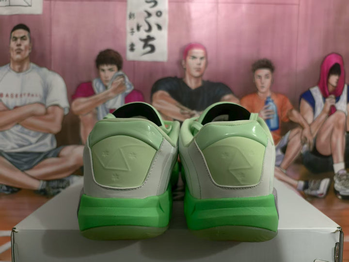 Rear view of the green and light gray Jordan sneakers showing the padded heels and bright green outsole sections.