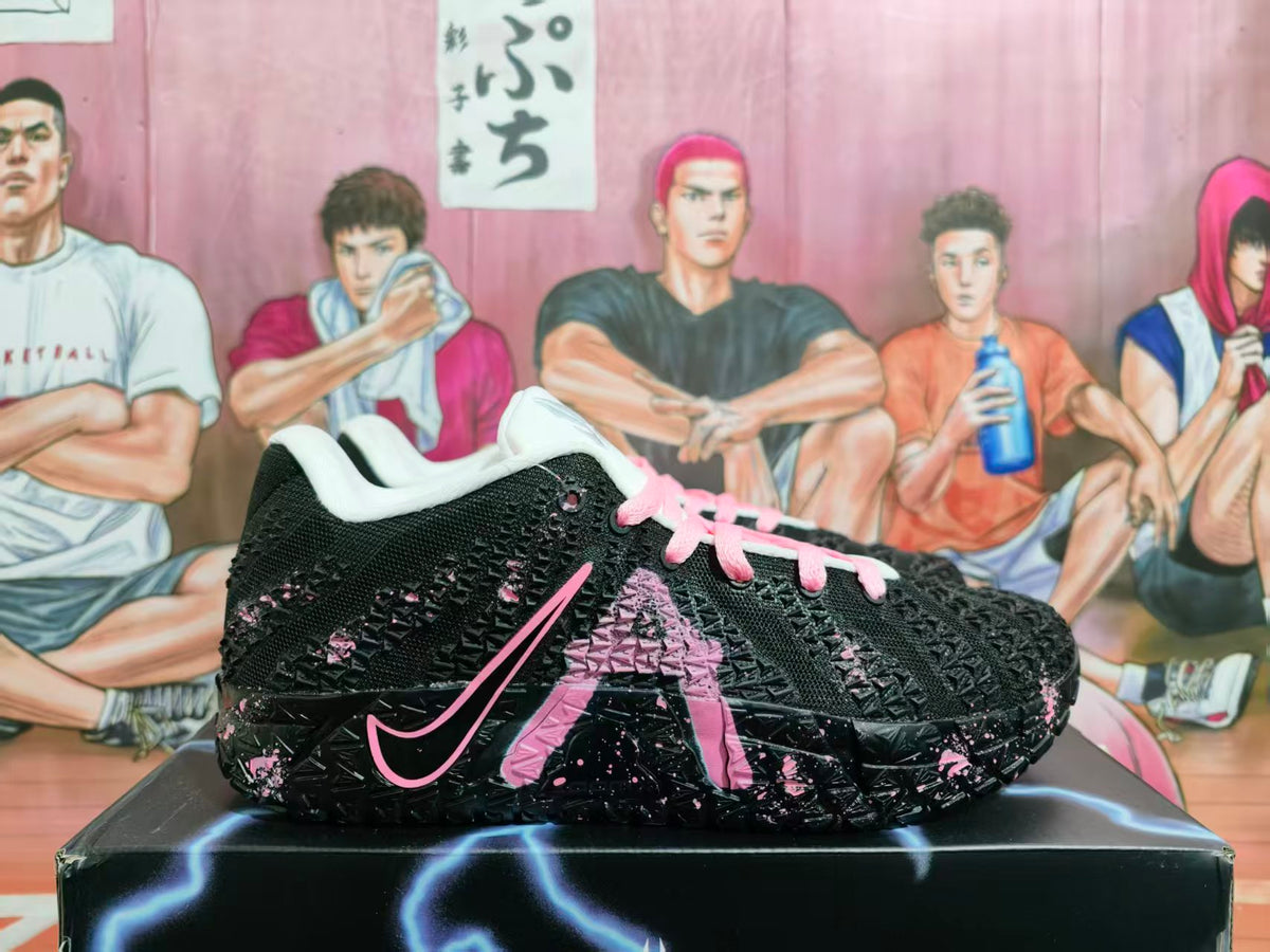 Side view of a black Nike basketball shoe with pink accents, pink laces, and a textured black sole.