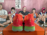 Rear view of the matching red sneakers with green heel and outsole accents.