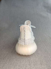 Rear view showing the heel construction, pull tab, silver detailing, and translucent outsole.