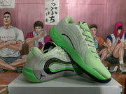 Angled view of light green Jordan basketball sneakers with black side detailing, gray speckled panels, and lace-up fronts.