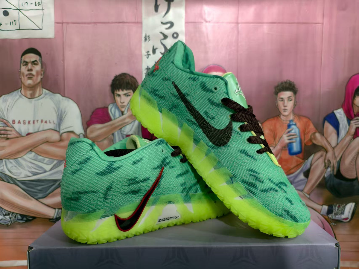 Pair of green Nike basketball sneakers with black laces, dark patterned detailing, and bright lime translucent outsoles displayed on a box.
