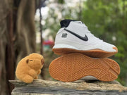 High-top sneaker shown above its patterned gum outsole, highlighting the tread design.