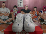 Front view of the white Nike sneakers showing white laces, perforated toe panels and dark navy Swoosh details.