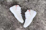 Angled overhead view of the white and red high-top sneakers.
