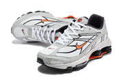 Pair of grey and white Nike Shox Ride 2 sneakers with orange accents, shown at an angled top view.