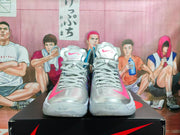 Front view of the silver high-top sneakers showing gray laces, pink toe accents, and Nike branding on the tongues.