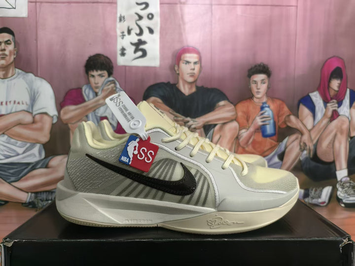 Side view of coconut milk-colored Nike basketball sneakers with a black Swoosh, pale outsole, and NBA and S-branded hangtags.
