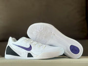 Side and outsole view of the white Nike Kobe 9 sneakers with purple Swoosh and black heel panels.