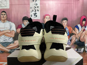 Rear view of beige basketball shoes with black and orange heel details and heel inscriptions