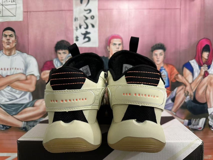 Rear view of beige basketball shoes with black and orange heel details and heel inscriptions