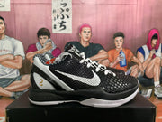 Side view of a black and white basketball sneaker with a white Swoosh, textured upper, and numbered heel detail.
