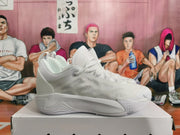 Side view of a white basketball sneaker with layered panels and a sculpted sole