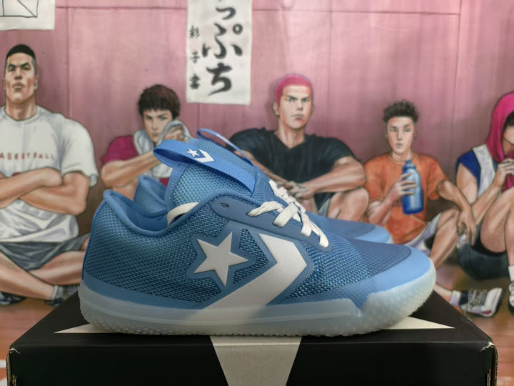 Blue low-top basketball-style sneakers with white laces, star-and-chevron side details, and translucent outsoles shown on a shoebox.