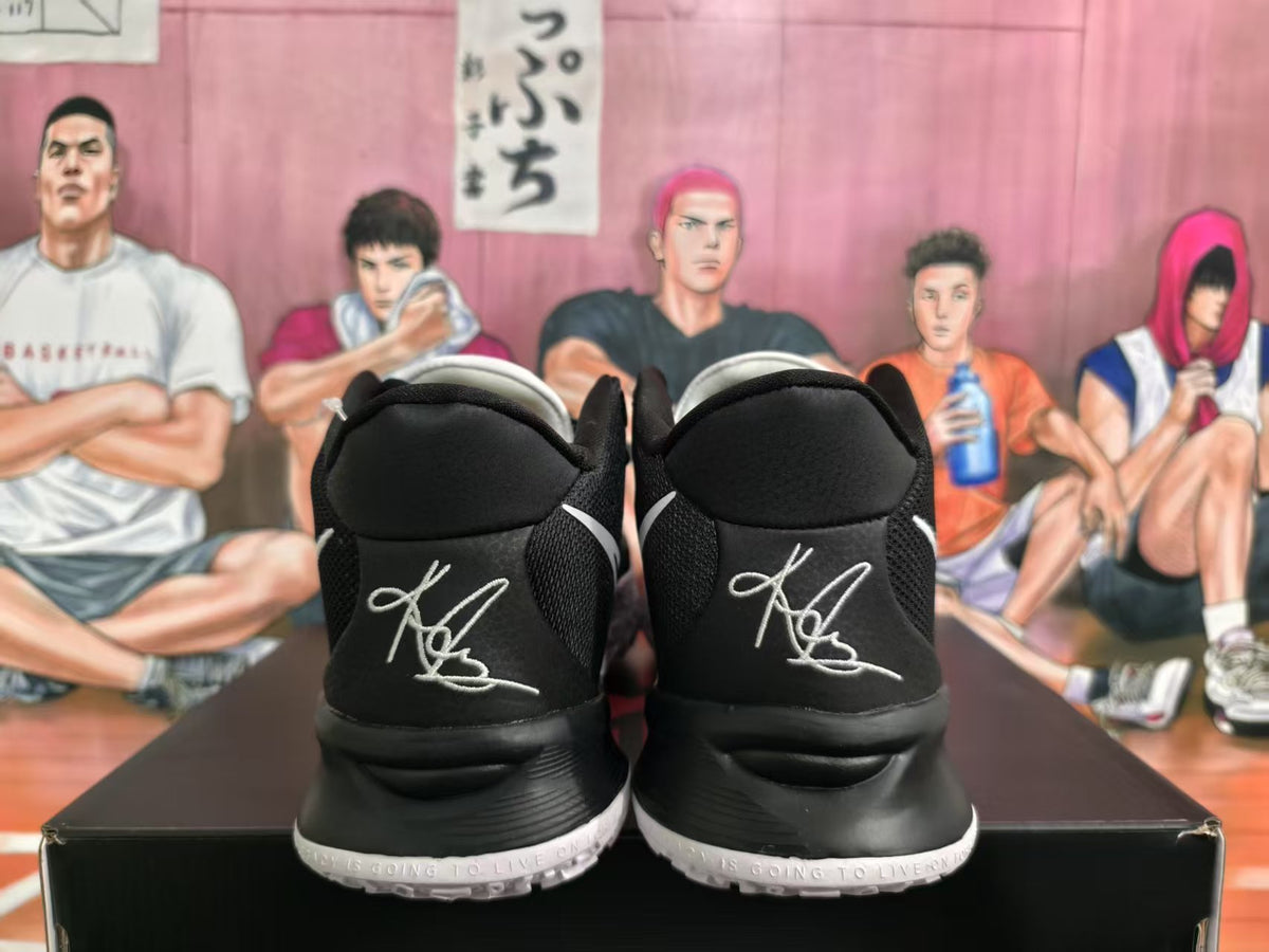 Rear view of black and white Nike basketball sneakers showing white heel embroidery, black collars, and white outsole edges.