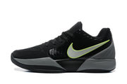 Side profile of a black sneaker with a large white and bright yellow outlined side logo and gray midsole.