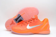 Bright orange Nike basketball sneaker shown beside its outsole, displaying the textured tread and dark midfoot insert.