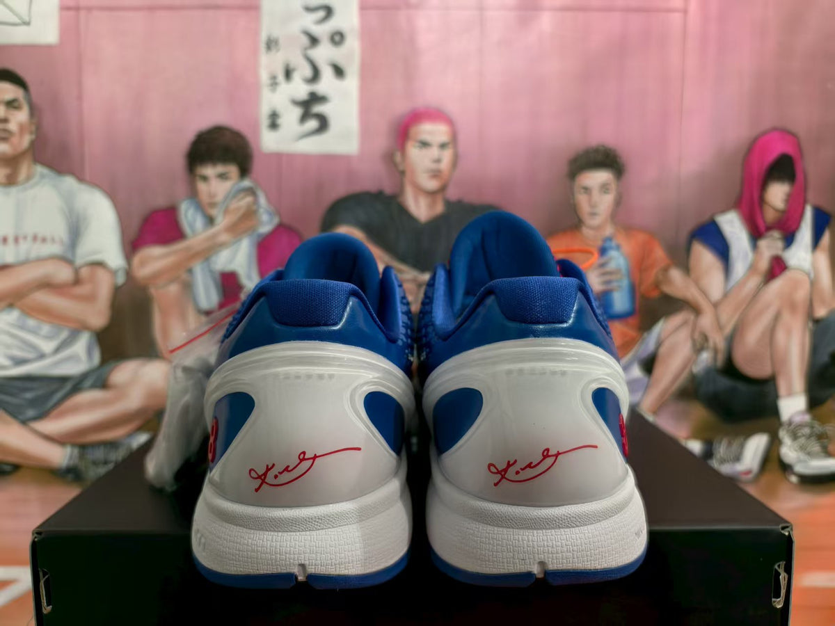 Rear view of blue and white Nike basketball sneakers showing the white midsoles, blue heel panels, red signature-style details, and red number 8 accents.