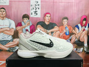 Side view showing the textured white upper and black Swoosh on a Nike Kobe shoe.