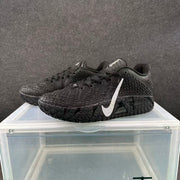 Pair of black basketball sneakers shown from a three-quarter angle with silver Swoosh branding and textured soles.