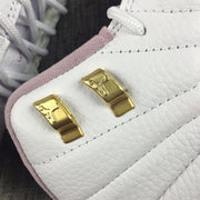 Close-up of the gold-toned lace hardware attached to the white upper.