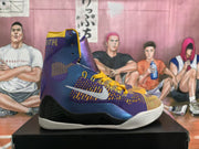 Side profile of a purple and gold high-top basketball shoe with a white swoosh, black lower panels, and a white ridged outsole.