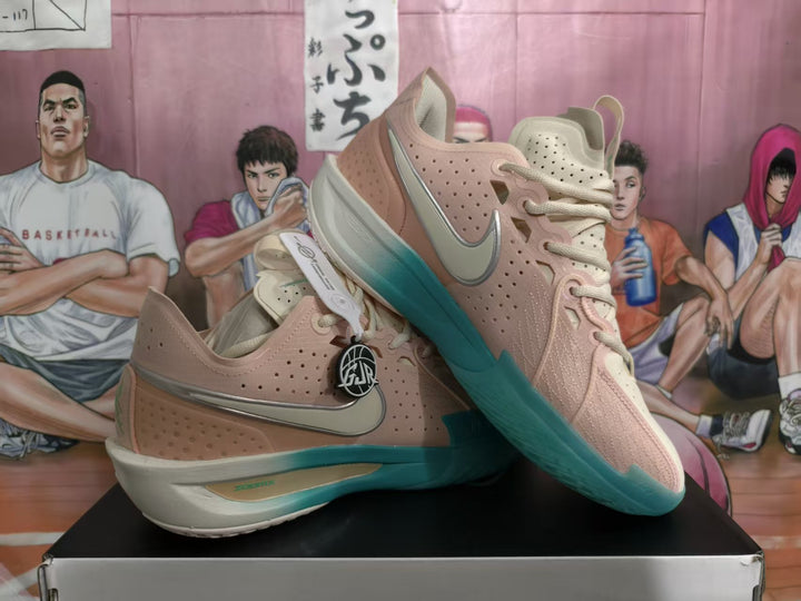 Pair of pink and cream Nike basketball sneakers with teal soles displayed on a box.
