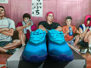 Front view of blue Nike sneakers showing layered toe panels, laces, and dark-blue outsoles.