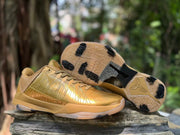 Pair of metallic gold Kobe 5 shoes with outsole visible