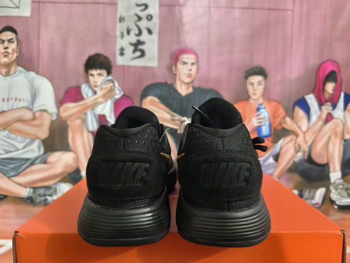 Rear view of black Nike sneakers showing black heel branding and the ridged outsole.