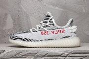 Outer side profile showing the black-and-white upper pattern, red side text, heel pull tab, and ribbed sole.
