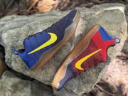 Angled view of blue and red Kobe 11 sneakers with translucent brown outsoles