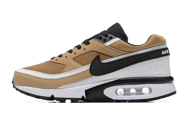 Side view of a tan, brown, black and white Nike low-top sneaker with a visible heel air-cushion unit.
