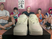 Front view of beige lace-up sneakers with rounded toe panels
