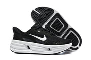 Black Nike Comfort Ride EasyOn sneakers shown from the side and outsole, with black-and-white tread.
