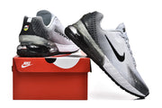 White and black Nike Air Max sneakers displayed with a red Nike shoe box.