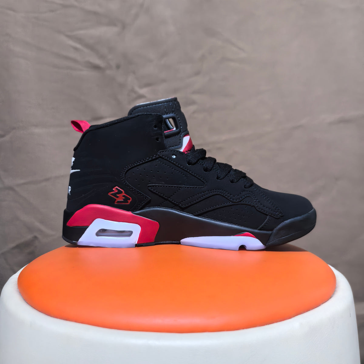 Side view of a black high-top sneaker with red and white accents