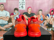 Rear view of a pair of red-orange basketball shoes showing the sculpted heel structures.