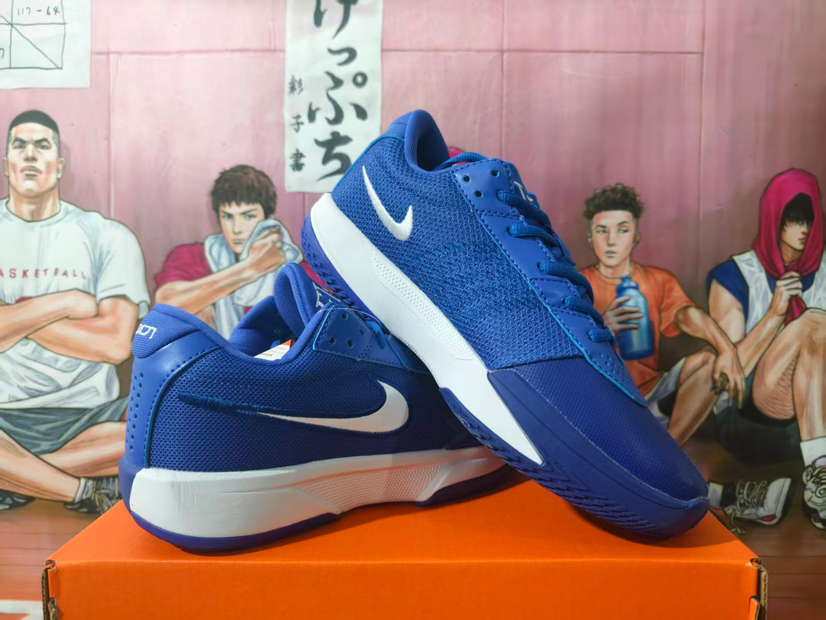 Pair of blue Nike basketball sneakers displayed on an orange shoebox, showing the side panels and layered white-and-blue soles.