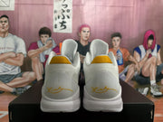 Rear view of the sneakers showing textured white collars, yellow heel tabs, and gold heel signature details.