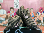 Pair of brown and black Nike basketball shoes with pale pink Swoosh details, shown from the side.