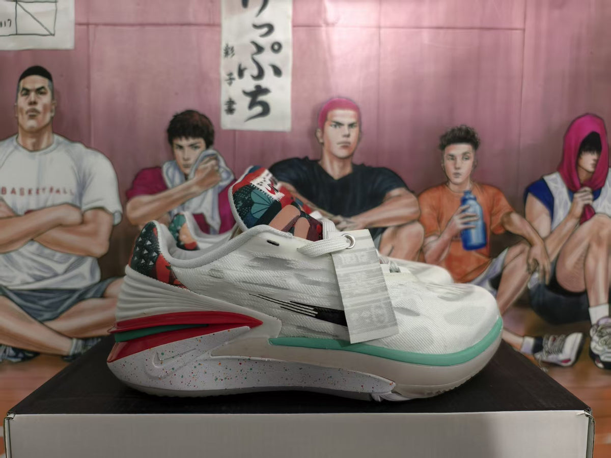 Side view of white Nike basketball sneakers with black branding, red and green accents, patterned heel panels, and a speckled midsole.