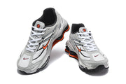 Pair of Nike Shox Ride 2 sneakers viewed from above, showing white laces, grey panels and orange accents.