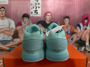 Rear view of mint green Nike sneakers showing the padded collars, heel panels and layered ribbed soles.