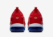 Rear view of the red sneakers showing heel details and dark blue soles.