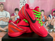 Angled view of the red Nike sneakers showing the textured upper, black swoosh, neon green laces, and translucent heel.