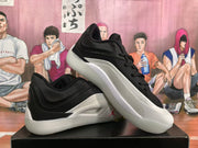 Angled view of a pair of black and white Jordan basketball sneakers showing the lateral side and white midsoles.