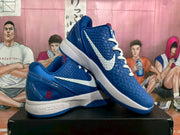 Angled view of the blue and white basketball sneakers, highlighting the textured upper, Swoosh, and heel number 8.