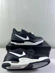Side and outsole view showing the black and white sneaker profile, strap, and circular outsole pattern.