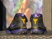 Rear view showing the yellow heel emblems, purple collar lining, and patterned outsole sections.